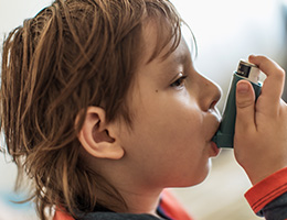 A young child using an inhaler. 