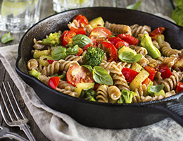 A cast iron skillet filled with pasta and vegetables.